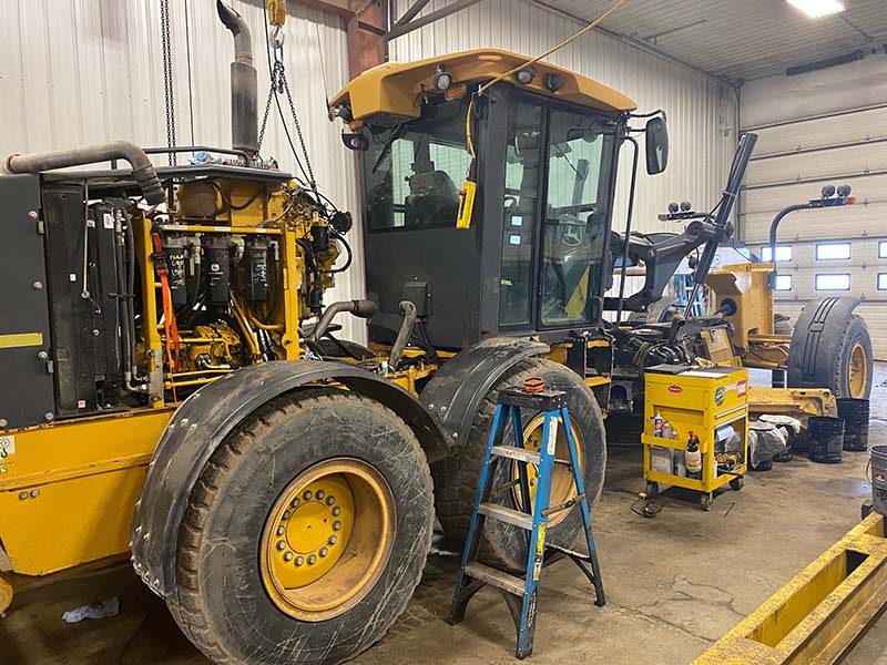 service shop working on a motor grader